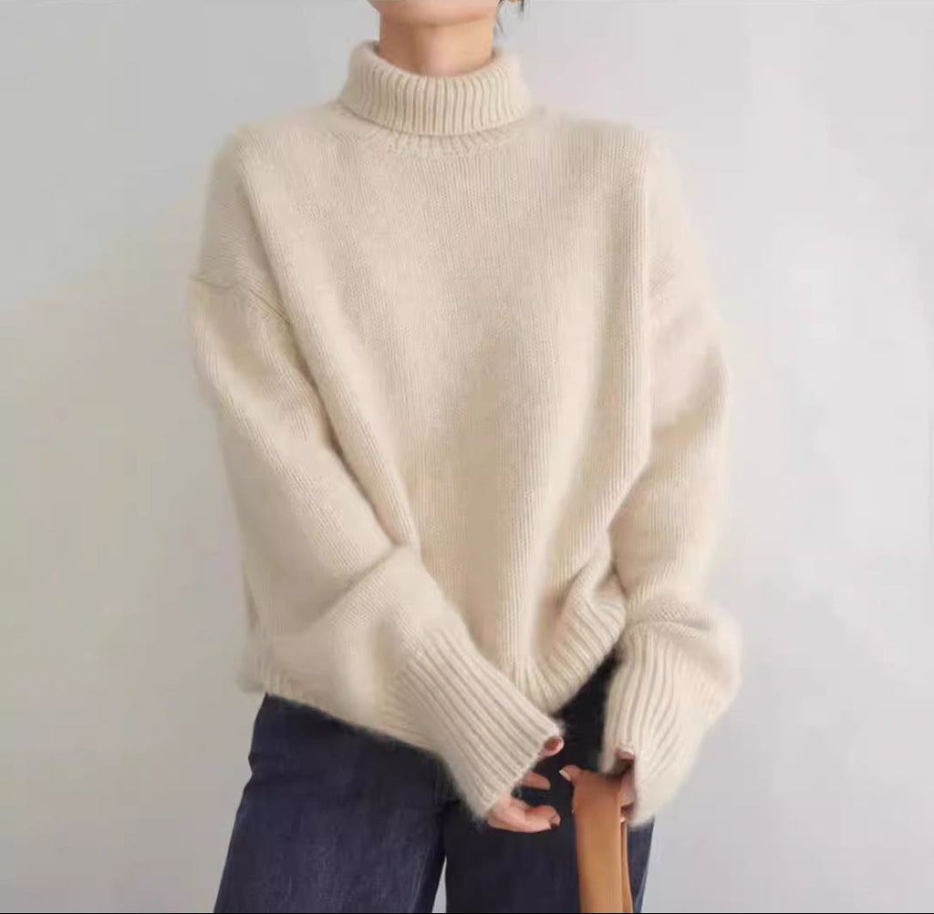 Beige sweater worn by a person on a plain background